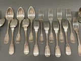 many spoons and forks laid out on the table
