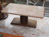 a marble table with a wooden base in the middle of a room