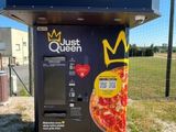 un distributeur automatique sur lequel est posée une pizza