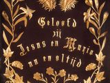 an old black and gold plaque with gold flowers and leaves