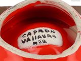 a close up of a red vase with writing on it