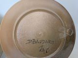 two brown plates with writing on them sitting on a table