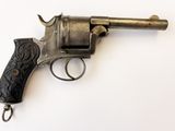 un vieux pistolet avec une poignée en bois sur une surface blanche