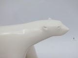 a white polar bear figurine sitting on a white surface