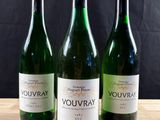 trois bouteilles de vin posées sur une table en bois