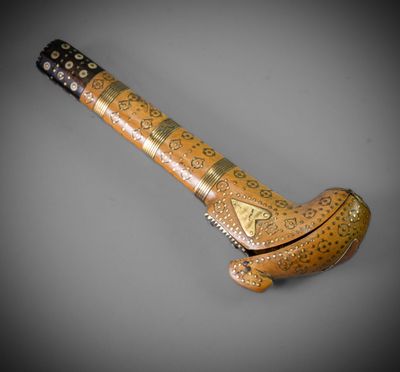 an old wooden pipe with a metal handle on a gray surface