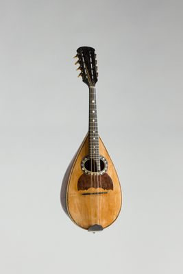 une vieille mandoline en bois posée sur un plan de travail blanc