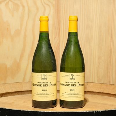 two bottles of wine sitting on top of a wooden barrel