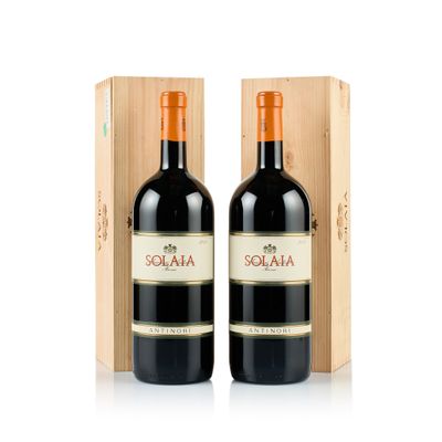 deux bouteilles de vin rouge devant une caisse en bois