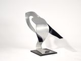 metal sculpture of a bird on a black base on a white background
