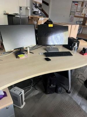 a desk with two monitors and a keyboard on it