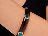 un gros plan sur le bras d'une femme portant un bracelet marron et vert