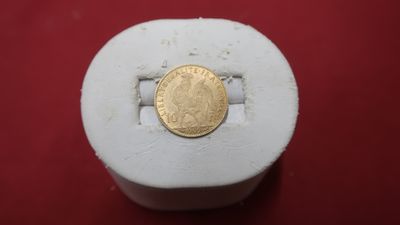 a gold coin sitting on top of a white object