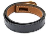 a close up of a black leather dog collar with a gold buckle