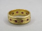 Gros plan sur une bague en or ornée de pierres rouges