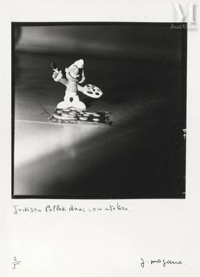 Photographie en noir et blanc d'un homme descendant une rue en skateboard