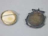 two pieces of jewelry that are sitting on a table
