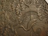 a metal plate with a picture of a bird and flowers on it