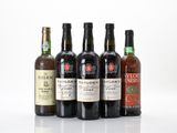 six bottles of wine are lined up on a white surface