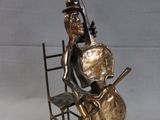 statue of a man sitting on a chair with a guitar and bass