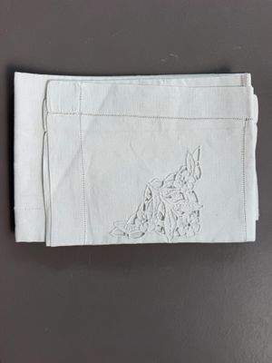 une serviette blanche ornée d'un motif de loup brodé, posée sur une table
