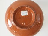 a brown bowl on a white table with a tag on it