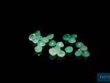 a close up of a group of green gems on a black surface