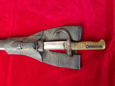 an old knife with a wooden handle on a red cloth