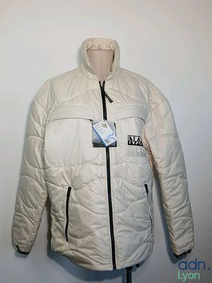 une veste posée sur un mannequin, avec une étiquette portant un nom