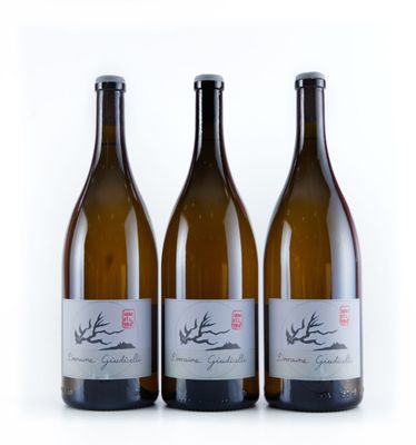 trois bouteilles de vin posées les unes à côté des autres sur une surface blanche