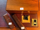 une boîte en bois avec, à côté, un stylo et un briquet