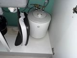 a water heater that is in the corner of a bathroom