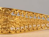 a gold brooch that is sitting on a table