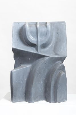 a gray sculpture that is sitting on a white surface