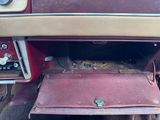 an old red car with a red seat and a brown seat cover