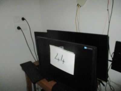 un téléviseur posé sur une table, à côté d'un clavier