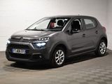 La Citroën grise est garée dans un garage au sol carrelé en damier.