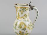 an image of a white and green vase with a bird on it