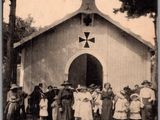 une vieille photo montrant un groupe de personnes debout devant une église