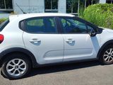 a small white car parked on the side of the road