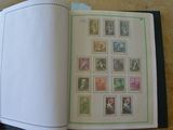 une personne tenant un livre sur lequel figurent des timbres
