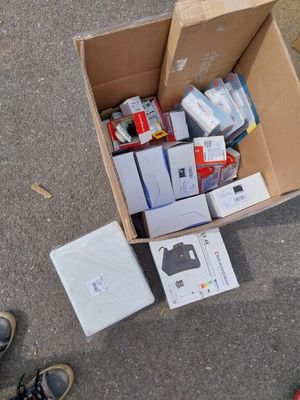 une boîte en carton remplie d'appareils électroniques posée par terre