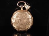 an image of a gold pocket watch sitting on a black surface