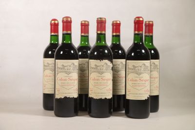 quatre bouteilles de vin sont alignées sur une surface blanche