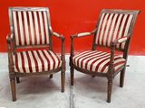 pair of antique wooden chairs with striped upholstered cushions