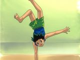 boy doing a handstand on the beach in front of the ocean