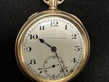 a gold pocket watch on a black surface