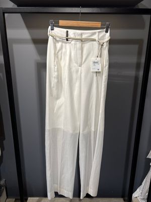 un pantalon blanc suspendu à un portant dans un magasin de vêtements