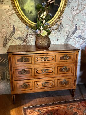 a picture of a dresser with a painting on the wall