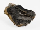 un gros plan sur un morceau de roche noire posé sur une surface blanche